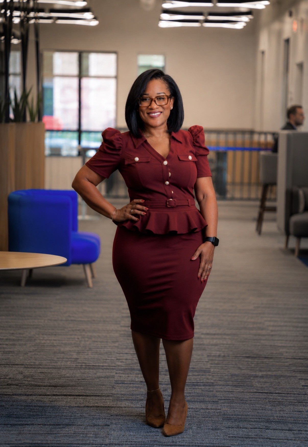 Kelli Turner in a burgundy dress in a modern workplace
