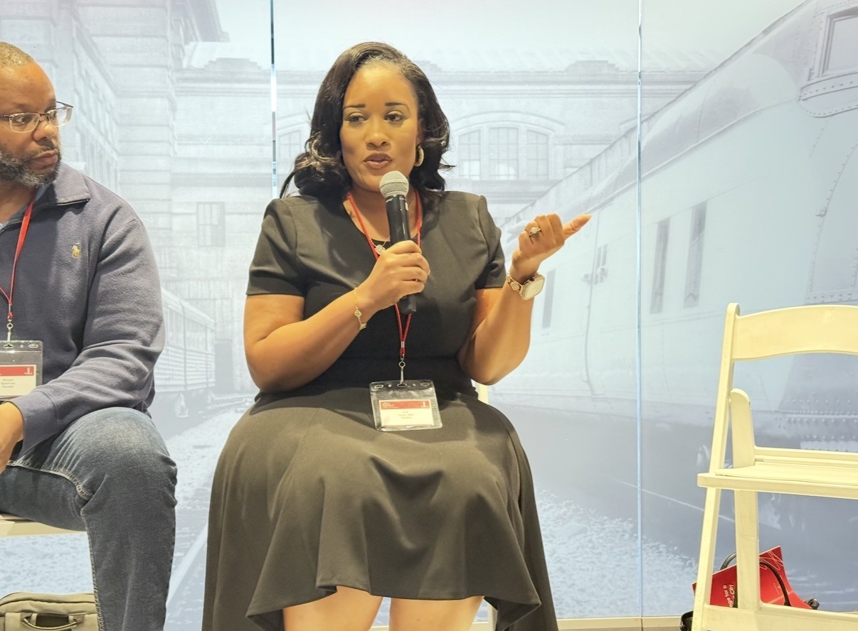 Kelli Turner speaking with a microphone at an event